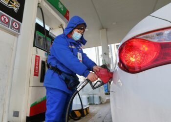 Seorang karyawan mengisi bensin kendaraan di sebuah stasiun pengisian bahan bakar umum di Kota Lianyungang, Provinsi Jiangsu, China timur, pada 29 Januari 2021. (Xinhua/Wang Jianmin)