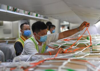 Seorang staf mengikat barang di pesawat kargo Hainan Airlines di Bandar Udara Internasional Meilan Haikou di Haikou, Provinsi Hainan, China selatan, pada 26 Maret 2021. (Xinhua/Pu Xiaoxu)