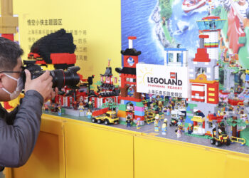 Seorang juru kamera mengambil gambar model Legoland Shanghai Resort yang mulai dibangun pada 17 November 2021. (Xinhua/Wang Xiang)