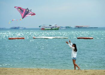Seorang wisatawan menerbangkan layang-layang di pantai di Pattaya, Provinsi Chonburi, Thailand, pada 16 November 2021. (Xinhua/Rachen Sageamsak)