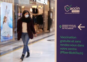 Seorang pelanggan berjalan melewati tanda yang menunjukkan pusat vaksinasi COVID-19 di dalam pusat perbelanjaan di Levallois-Perret dekat Paris, Prancis, pada 9 November 2021. (Xinhua/Gao Jing)