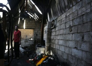 Seorang pria berdiri di dalam reruntuhan sebuah pabrik, yang hancur pada Selasa (23/11) pagi waktu setempat dalam serangan udara dari koalisi pimpinan Arab Saudi, di Sanaa, Yaman, pada 23 November 2021. (Xinhua/Mohammed Mohammed)