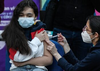 Seorang anak menerima suntikan dosis vaksin COVID-19 Sinovac di Santiago, Chile, pada 27 September 2021. (Xinhua/Jorge Villegas)