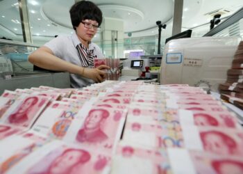 Foto dokumentasi ini menunjukkan seorang pekerja menghitung mata uang Renminbi (RMB) China di sebuah bank di Lianyungang, Provinsi Jiangsu, China timur. (Xinhua/Si Wei)