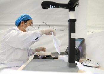 Seorang tenaga kesehatan bekerja di laboratorium pengujian dengan struktur yang ditumpu udara (air-inflated) "Falcon" untuk tes asam nukleat COVID-19 di Dalian, Provinsi Liaoning, China timur laut, pada 15 November 2021. (Xinhua/Yao Jianfeng)