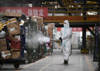 Seorang staf mendisinfeksi paket di sebuah pusat logistik di Yinchuan, Daerah Otonom Etnis Hui Ningxia, China barat laut, pada 10 November 2021. (Xinhua/Wang Peng)