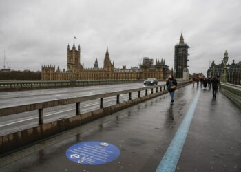 Orang-orang berjalan di depan Gedung Parlemen di London, Inggris, pada 13 Desember 2020. (Xinhua/Han Yan)