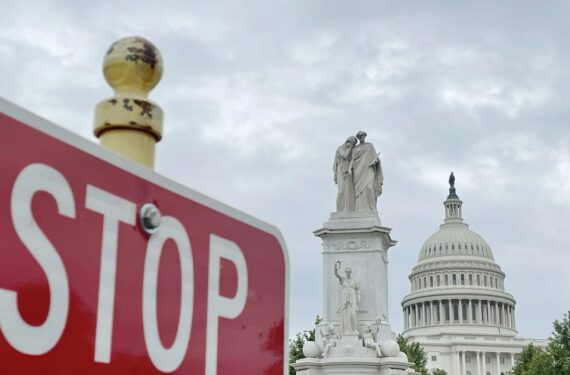 Foto yang diabadikan pada 28 Mei 2021 ini menunjukkan gedung Capitol AS di belakang sebuah rambu lalu lintas di Washington DC, Amerika Serikat. (Xinhua/Liu Jie)