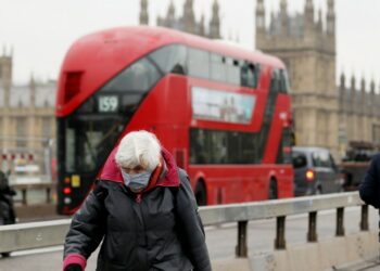 Seorang wanita yang mengenakan masker menyusuri Jembatan Westminster di London, Inggris, pada 24 November 2021. (Xinhua/Li Ying)