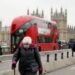 Seorang wanita yang mengenakan masker menyusuri Jembatan Westminster di London, Inggris, pada 24 November 2021. (Xinhua/Li Ying)