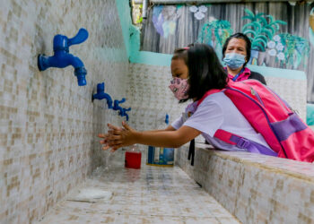 QUEZON CITY, Seorang siswa yang mengenakan masker mencuci tangannya sebelum mengikuti kelas tatap muka di sebuah sekolah dasar di Quezon City, Filipina, pada 6 Desember 2021. Sekolah-sekolah tertentu di Filipina pada Senin (6/12) memulai uji coba kelas tatap muka terbatas seiring Filipina terus melaporkan penurunan kasus COVID-19. (Xinhua/Rouelle Umali)