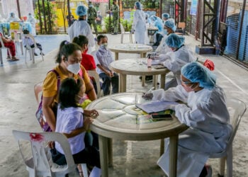 QUEZON CITY, Para siswa yang mengenakan masker dibantu orang tua mereka saat melakukan tes antigen COVID-19 secara sukarela sebelum mengikuti kelas tatap muka di sebuah sekolah dasar di Quezon City, Filipina, pada 6 Desember 2021. Sekolah-sekolah tertentu di Filipina pada Senin (6/12) memulai uji coba kelas tatap muka terbatas seiring Filipina terus melaporkan penurunan kasus COVID-19. (Xinhua/Rouelle Umali)