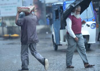 AGARTALA, Orang-orang berjalan di tengah hujan di Agartala, ibu kota Negara Bagian Tripura, India timur laut, pada 6 Desember 2021. (Xinhua/Str)