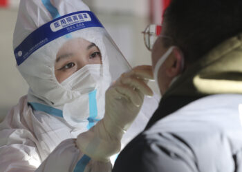 HARBIN, Tenaga kesehatan mengambil sampel usap (swab) dari seorang penduduk untuk tes asam nukleat di lokasi pengambilan sampel di Distrik Xiangfang, Harbin, Provinsi Heilongjiang, China timur laut, pada 6 Desember, 2021. Harbin pada Senin (6/12) meluncurkan putaran ketiga tes asam nukleat inklusif di beberapa daerah sejak kasus-kasus terkonfirmasi baru COVID-19 yang ditularkan secara lokal dilaporkan. (Xinhua/Zhang Tao)