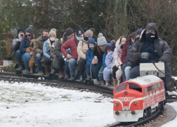 BUDAPEST, Orang-orang menaiki gerbong kereta mini di tengah salju pertama di tengah Perayaan Santa di Museum Kereta Hongaria di Budapest, Hongaria, pada 5 Desember 2021. (Xinhua/Attila Volgyi)