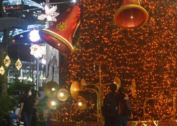 SINGAPURA, Orang-orang mengabadikan foto dekorasi lampu Natal di sekitar Orchard Road di Singapura, pada 9 Desember 2021. (Xinhua/Then Chih Wey)