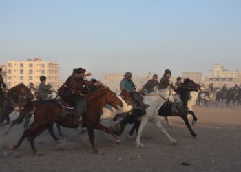 BALKH, Para penunggang kuda Afghanistan bersaing memperebutkan bangkai kambing dalam pertandingan Buzkashi di Mazar-i-Sharif, ibu kota Provinsi Balkh, Afghanistan, pada 10 Desember 2021. Buzkashi atau "perebutan kambing" merupakan sebuah permainan tradisional yang keras di Afghanistan, di mana para penunggang kuda bersaing sengit memperebutkan bangkai kambing dan melemparkannya ke "gawang" yang berupa sebuah lingkaran di lapangan. (Xinhua/Kawa Basharat)