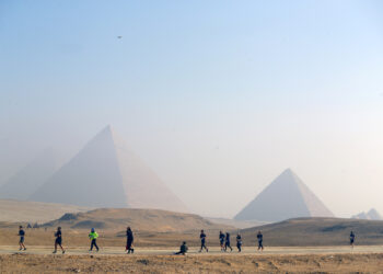 GIZA, Para kontestan berlari dalam ajang Pyramids Half Marathon yang diadakan di objek wisata Piramida Giza di Giza, Mesir, pada 11 Desember 2021. (Xinhua/Ahmed Gomaa)