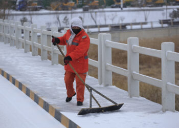 WUWEI, Seorang petugas membersihkan salju di sepanjang jembatan di Wuwei, Provinsi Gansu, China barat laut, pada 11 Desember 2021. (Xinhua/Jiang Aiping)