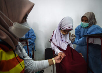 TANGERANG SELATAN, Seorang anak perempuan menerima dosis vaksin COVID-19 Sinovac China di Tangerang Selatan, Provinsi Banten, pada 14 Desember 2021. Indonesia memulai vaksinasi COVID-19 bagi anak-anak berusia enam hingga 11 tahun pada Selasa (14/12). (Xinhua/Agung Kuncahya B.)