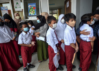 TANGERANG SELATAN, Anak-anak menunggu untuk menerima suntikan vaksin COVID-19 Sinovac China di Tangerang Selatan, Provinsi Banten, pada 14 Desember 2021. Indonesia memulai vaksinasi COVID-19 bagi anak-anak berusia enam hingga 11 tahun pada Selasa (14/12). (Xinhua/Agung Kuncahya B.)