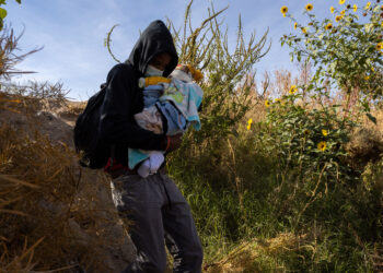 CIUDAD JUAREZ, Seorang migran yang menggendong bayi menyeberangi Sungai Rio Bravo, seperti yang terlihat dari Ciudad Juarez, di Negara Bagian Chihuahua, Meksiko, pada 13 Desember 2021. (Xinhua/David Peinado)