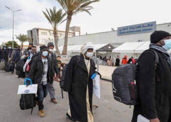 TRIPOLI, Para imigran berjalan di Bandar Udara Internasional Mitiga di Tripoli, Libya, pada 15 Desember 2021. Sebanyak 138 imigran ilegal secara sukarela dideportasi dari Libya ke Sudan pada Rabu (15/12). (Xinhua/Hamza Turkia)