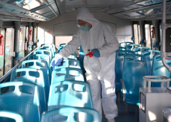 XI'AN, Seorang staf mendisinfeksi sebuah bus di Xi'an, Provinsi Shaanxi, China barat laut, pada 21 Desember 2021. (Xinhua/Shao Rui)