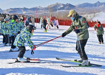 QINGZHOU, Seorang instruktur mengajari seorang anak bermain ski di sebuah resor ski di Kota Qingzhou, Provinsi Shandong, China timur, pada 25 Desember 2021. (Xinhua/Wang Jilin)