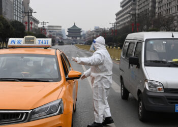 XI'AN, Seorang petugas polisi memeriksa sebuah kendaraan Taxi di Xi'an, Provinsi Shaanxi, China barat laut, pada 27 Desember 2021. Xi'an meningkatkan kebijakan antiepideminya dan menerapkan manajemen tertutup paling ketat mulai Senin (27/12) untuk meredam penyebaran lonjakan terbaru COVID-19. (Xinhua/Tao Ming)