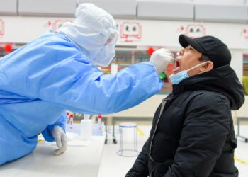 Tenaga kesehatan mengambil sampel usap (swab) dari seorang warga untuk tes asam nukleat di sebuah lokasi tes COVID-19 di Manzhouli, Daerah Otonom Mongolia Dalam, China utara, pada 29 November 2021. (Xinhua/Li Zhipeng)