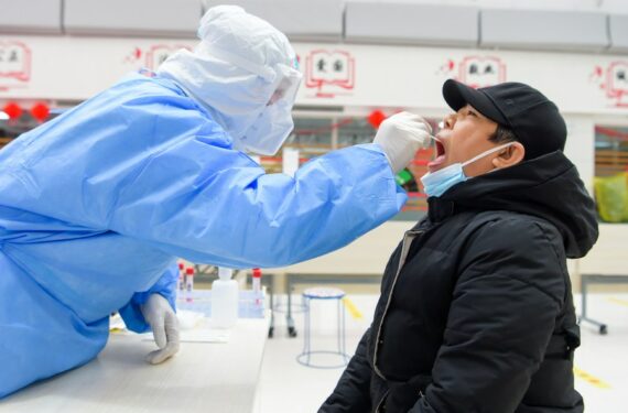 Tenaga kesehatan mengambil sampel usap (swab) dari seorang warga untuk tes asam nukleat di sebuah lokasi tes COVID-19 di Manzhouli, Daerah Otonom Mongolia Dalam, China utara, pada 29 November 2021. (Xinhua/Li Zhipeng)