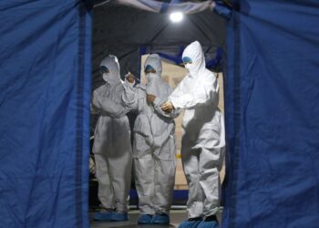 Para staf mengenakan alat pelindung diri (APD) sebelum memasuki laboratorium uji dengan struktur yang ditumpu udara (air-inflated), yang dinamai "Falcon" (Elang), untuk pengujian asam nukleat COVID-19 di Dalian, Provinsi Liaoning, China timur laut, pada 24 November 2021. (Xinhua/Yao Jianfeng)