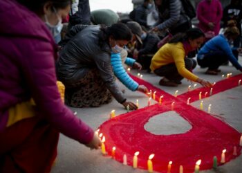 Para relawan menyalakan lilin dalam kampanye meningkatkan kesadaran tentang AIDS pada malam menjelang Hari AIDS Sedunia di Kathmandu, Nepal, pada 30 November 2021. (Xinhua/Sulav Shrestha)