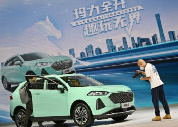 Pengunjung mengamati sebuah mobil baru dari WEY, merek mobil keluaran produsen otomotif China Great Wall Motors (GWM), dalam ajang China (Tianjin) Auto Show 2021 di Tianjin, China utara, pada 29 September 2021. (Xinhua/Li Ran)
