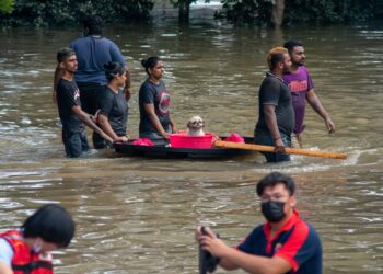 Korban banjir mengarungi jalan yang tergenang air di Shah Alam, Selangor, Malaysia, pada 20 Desember 2021. (Xinhua/Chong Voon Chung)