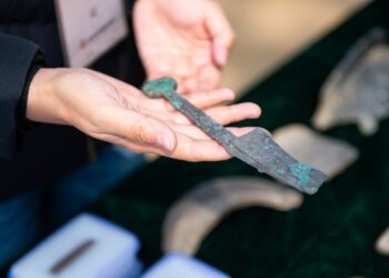 Seorang arkeolog menunjukkan sebuah benda peninggalan yang ditemukan di situs relik Liulihe di wilayah barat daya Beijing pada 8 April 2021. (Xinhua/Chen Zhonghao)