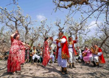Penduduk setempat menari menyambut turis di Awat di Kota Korla, Daerah Otonom Uighur Xinjiang, China barat laut, pada 10 April 2021. (Xinhua/Zhao Ge)