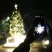 Seorang pria memotret pohon Natal dengan ponsel di Islamabad, ibu kota Pakistan, pada 8 Desember 2021. (Xinhua/Ahmad Kamal)