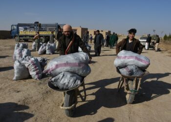 Orang-orang menerima bantuan yang disumbangkan oleh seorang dermawan setempat di Distrik Nahr Shahi di Provinsi Balkh, Afghanistan, pada 21 November 2021. (Xinhua/Kawa Basharat)