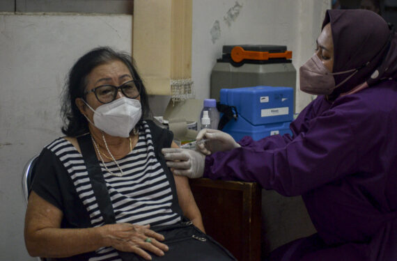 BOGOR, Seorang tenaga kesehatan menyuntikkan satu dosis vaksin COVID-19 kepada seorang wanita dalam program vaksinasi di Kelurahan Cimahpar, Kota Bogor, Jawa Barat, pada 14 Januari 2022. (Xinhua/Sandika Fadilah)