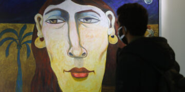 KAIRO, Seorang pengunjung mengamati lukisan di sebuah pameran seni dalam ajang Forum Seni Dunia pertama Mesir di Kairo, Mesir, pada 16 Januari 2022. (Xinhua/Sui Xiankai)