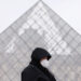 PARIS, Seorang wanita berjalan melewati piramida Museum Louvre di Paris, Prancis, pada 19 Januari 2022. Situasi COVID-19 terus memburuk di Prancis setelah 464.769 kasus baru terdeteksi dalam 24 jam terakhir, seperti diumumkan badan kesehatan masyarakat negara itu pada Selasa (18/1). (Xinhua/Gao Jing)