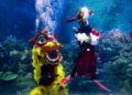 KUALA LUMPUR, Para penyelam yang mengenakan kostum barongsai dan Dewa Keberuntungan menampilkan pertunjukan dalam air untuk merayakan Tahun Baru Imlek selama acara pratinjau media di akuarium Aquaria KLCC di Kuala Lumpur, Malaysia, pada 21 Januari 2022. (Xinhua/Zhu Wei)