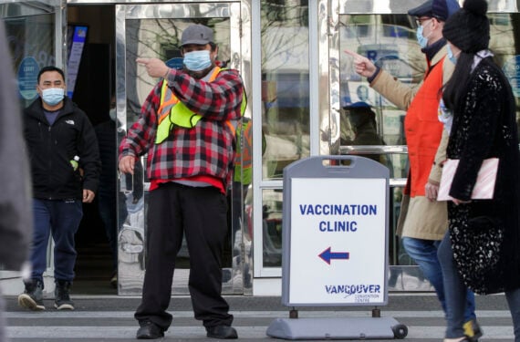 VANCOUVER, Seorang staf menunjukkan arah ke sebuah klinik vaksinasi kepada orang-orang di Vancouver, British Columbia, Kanada, pada 22 Januari 2022. Kanada pada Sabtu (22/1) sore mengonfirmasi 13.555 kasus baru COVID-19, menambah total kasus nasional menjadi 2.905.560 dengan 32.502 kematian, lapor CTV. (Xinhua/Liang Sen)