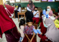 BOGOR, Tenaga kesehatan menyuntikkan vaksin COVID-19 kepada seorang anak laki-laki dalam program vaksinasi untuk anak usia 6 hingga 11 tahun di Bogor, Provinsi Jawa Barat, pada 26 Januari 2022. (Xinhua/Sandika Fadilah)