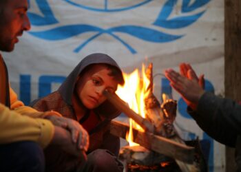 Warga Palestina menghangatkan diri di sekitar api unggun di sebuah kamp pengungsi di Kota Khan Younis, Jalur Gaza selatan, pada 30 Desember 2021. (Xinhua/Yasser Qudih)