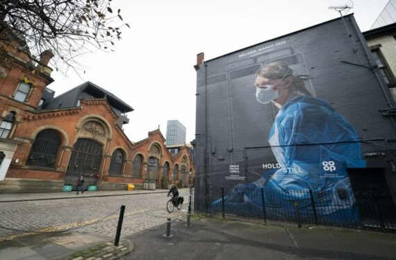 Orang-orang melewati lukisan mural seorang perawat yang baru dibuat di Manchester, Inggris, pada 5 November 2020. (Xinhua/Jon Super)