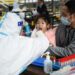 Tenaga kesehatan mengambil sampel usap dari seorang anak untuk tes asam nukleat di sebuah fasilitas pengujian COVID-19 di Distrik Futian di Shenzhen, Provinsi Guangdong, China selatan, pada 9 Januari 2022. (Xinhua/Liang Xu)