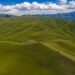 Foto dari udara yang diabadikan pada 15 Juni 2021 ini menunjukkan pemandangan padang rumput musim panas di Gunung Barlik di wilayah Yumin, Daerah Otonom Uighur Xinjiang, China barat laut. (Xinhua/Hu Huhu)
